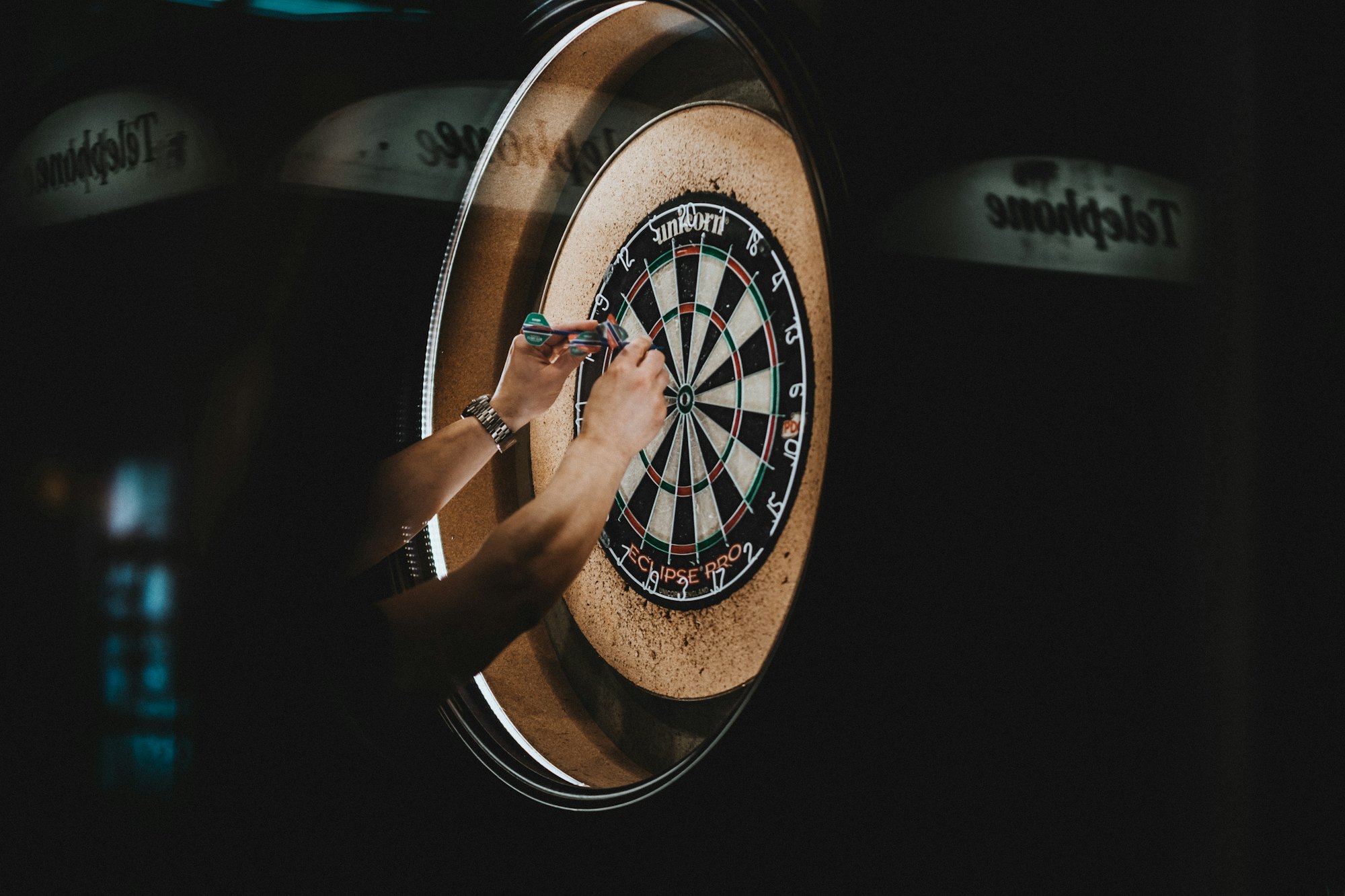 A dart being thrown at a dartboard